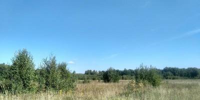 skön landskap. natur bild bakgrund. vår natur. blå klar himmel. solljus och fluffig moln. fält och äng. foto