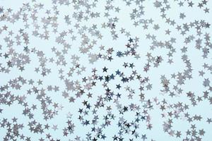 silver- folie konfetti stjärnor på blå bakgrund foto