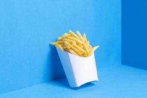 saltade pommes frites på blå bakgrund