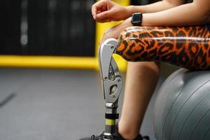 ung kvinna med ett protes- ben med de öva av använder sig av protes- ben till promenad, övning och och dagligen aktiviteter foto