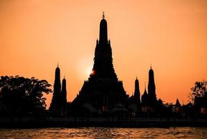 närbild silhuett av wat arun tempel vid solnedgången i bangkok, thailand foto