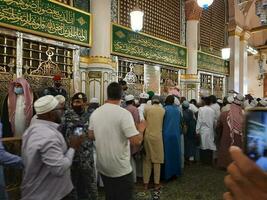 medina, saudi Arabien, april 2023 - muslim pilgrimer är gående till besök roza rasool på masjid al nabawi madinah. foto