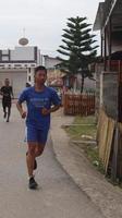 gorontalo, Mars 2023 - maraton löpning lopp, människor fötter på stad väg. löpning människor på en maraton konkurrens foto