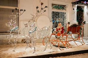 lysdioder figur santa claus ridning på släde under jul mot restaurang eller Lagra i Semester vinter- stad - festlig och högtider säsong foto