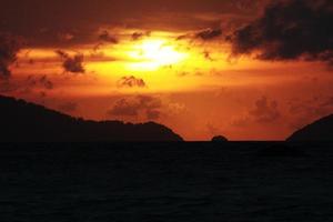 skön marinmålning och tropisk ö med himmel i skymning av solnedgång över de berg i hav på thailand foto