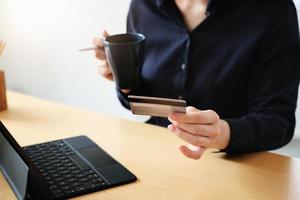 kvinna som håller kaffe och ett kreditkort foto
