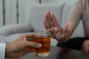 man vägrar säga Nej och undvika till dryck ett alkohol whisky , stoppa hand tecken manlig, alkoholism behandling, alkohol missbruk, sluta sprit, sluta dricka alkohol. vägra glas sprit, ohälsosam, avvisa foto