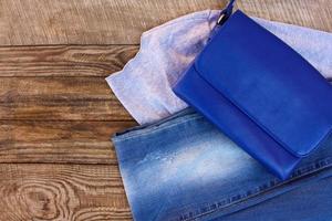 kvinnors Kläder och Tillbehör Tröja, jeans, handväska på trä- bakgrund. tonad bild. foto