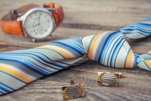 slips, manschettknappar och klockor på de gammal trä bakgrund foto