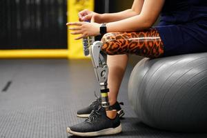 ung kvinna med ett protes- ben med de öva av använder sig av protes- ben till promenad, övning och och dagligen aktiviteter foto