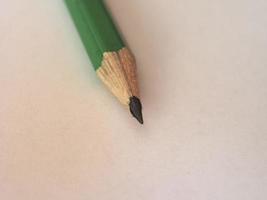 grön penna på papper ark foto
