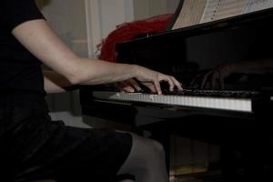 närbild på de händer av en kvinna spelar de piano med musik nycklar foto