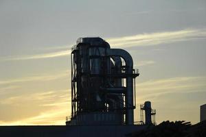 metall rör i fabrik, solnedgång himmel foto