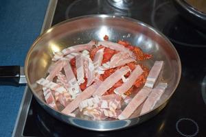 skivad bacon med morötter, paprika och skalad tomat foto