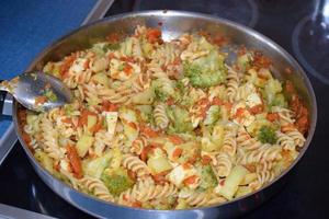 ett pott pasta med morötter och broccoli foto