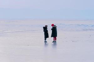 människor i vinterkläder som står på den isiga ytan av havet. vladivostok. foto