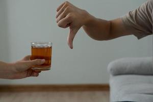 man vägrar säga Nej och undvika till dryck ett alkohol whisky , stoppa hand tecken manlig, alkoholism behandling, alkohol missbruk, sluta sprit, sluta dricka alkohol. vägra glas sprit, ohälsosam, avvisa foto