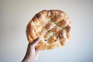 pOV skott av innehav en ramadan pide, turkiska populär bröd, foto