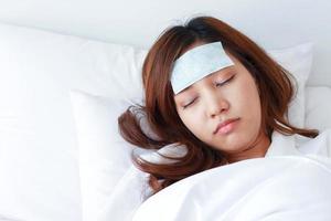 ung asiatisk kvinna är sjuk och sover i sängen. foto