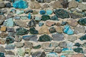 gammal stenvägg med färgglada stenar