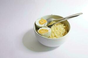 omedelbar spaghetti med Anka ägg i en skål på en vit bakgrund foto