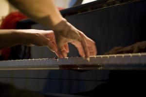 närbild på de händer av en kvinna spelar de piano med musik nycklar foto