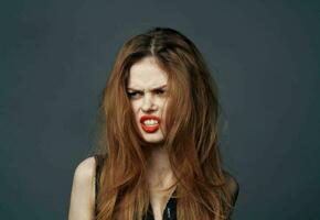 porträtt av rödhårig kvinna med röd mun känslor modell grå bakgrund foto