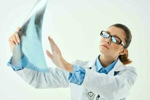 kvinna läkare i vit täcka ser på röntgen diagnostik närbild foto
