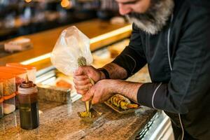 sushi kock framställning mat på en sushi bar. foto