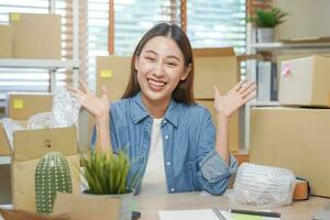 glad små företag entreprenör sme, Lycklig asiatisk ung kvinna ägare leende när motta beställa från kund på app handla förbi smartphone, mobil. handlare uppkopplad, e-handel arbetssätt på Hem kontor. foto