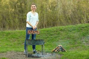 ung flicka framställning mat på grill foto