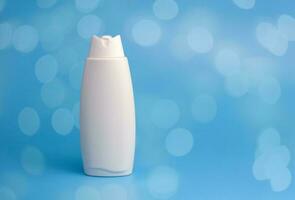 vit behållare för kosmetika, schampo, gel, kropp vård produkt på en blå bakgrund med bokeh lampor. foto