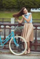ung vacker, elegant klädd kvinna med cykel foto
