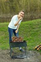 ung flicka framställning mat på grill foto