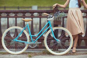 ung vacker, elegant klädd kvinna med cykel foto