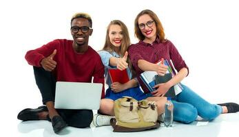 tre Lycklig ung tonåring studenter med tummen upp isolerat på vit foto