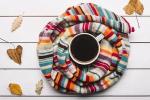 halsduk med höstlöv som ligger runt kaffe foto