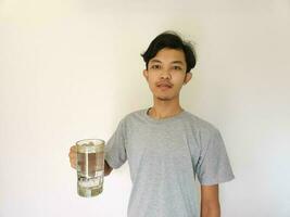 asiatisk man har en glas av vatten på isolerat bakgrund foto