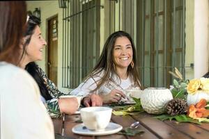 grupp av Lycklig kvinnor samlade in i en Land hus, delning te. foto