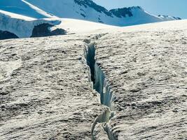 stor spricka på de glaciär. fel i en glaciär, en farlig spricka i de is på de snöig backe av en glaciär. foto