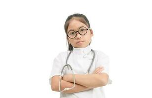 söt asiatisk barn i läkare täcka med stetoskop isolerat foto