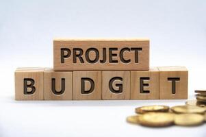 projekt budget text graverat på trä- block på vit bakgrund omslag. företag och budgetering begrepp foto
