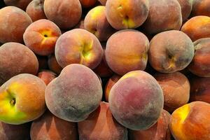 stack av persikor på en marknadsföra bås foto