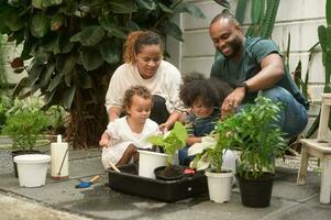 Lycklig afrikansk amerikan familj njuter trädgårdsarbete på Hem foto
