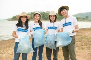volontärer från de asiatisk ungdom gemenskap använder sig av skräp påsar rengöring upp natur par foto