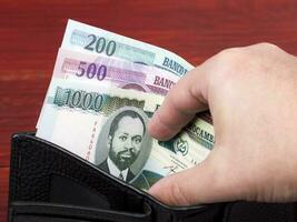 mozambikanska pengar - metiska i de svart plånbok foto
