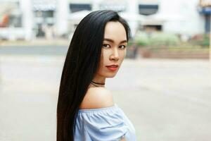 skön ung asiatisk kvinna med bar axlar i de stad foto