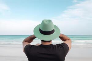 tillbaka se av en man bär en hatt Sammanträde på en strand. ai genererad foto