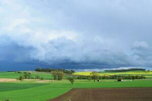 blå storm molnig ovan en lantlig vår landscpae foto