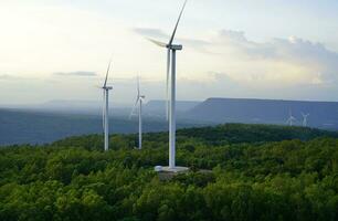 vind energi. vind kraft. hållbar, förnybar energi. vind turbiner generera elektricitet. väderkvarn bruka på berg med solnedgång himmel. grön teknologi. förnybar resurs. hållbar utveckling. foto